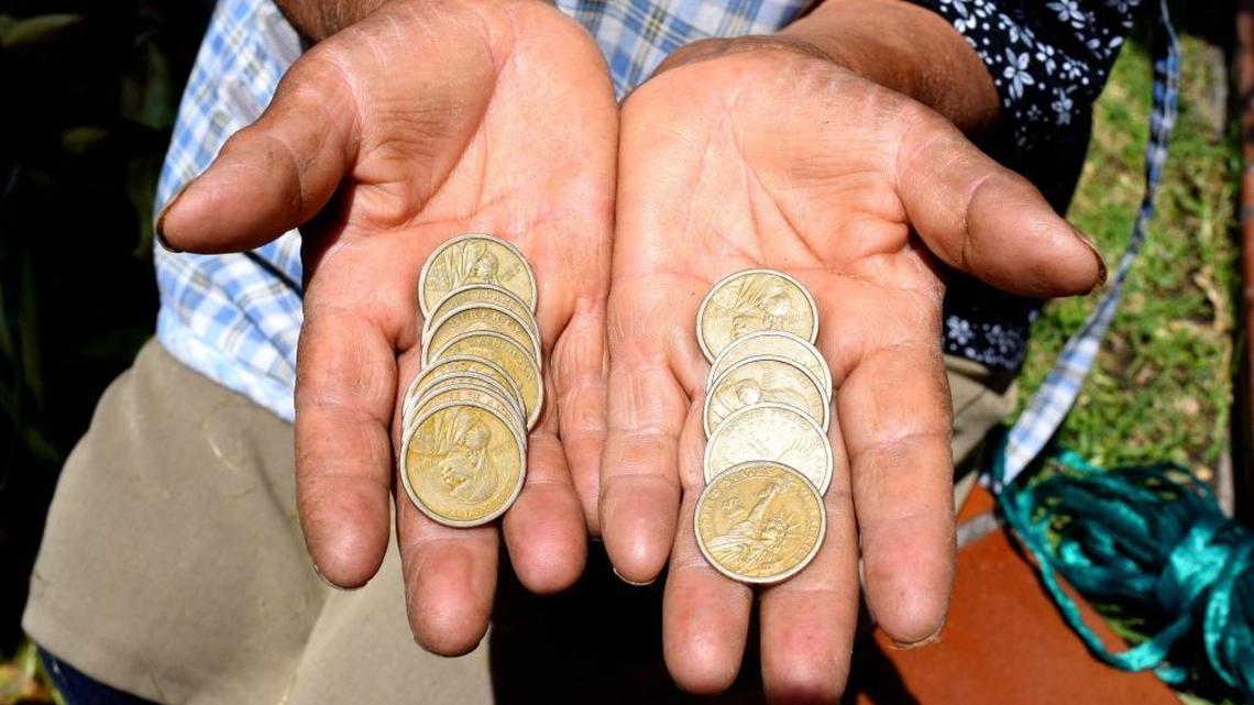 Luzmila Mita holds Sacagawea dollar coins in Quito, Ecuador. Sacagawea, an 18th Century Shoshone tribeswoman, is seen as something of a kindred spirit in Ecuador