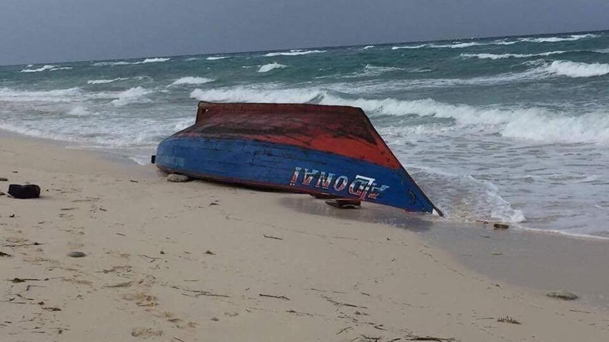 A boat painted in the colors of the Haitian flag was seen capsized on a beach in Providenciales in the Turks and Caicos Islands on Tuesday morning where 10 bodies were found floating in the ocean.