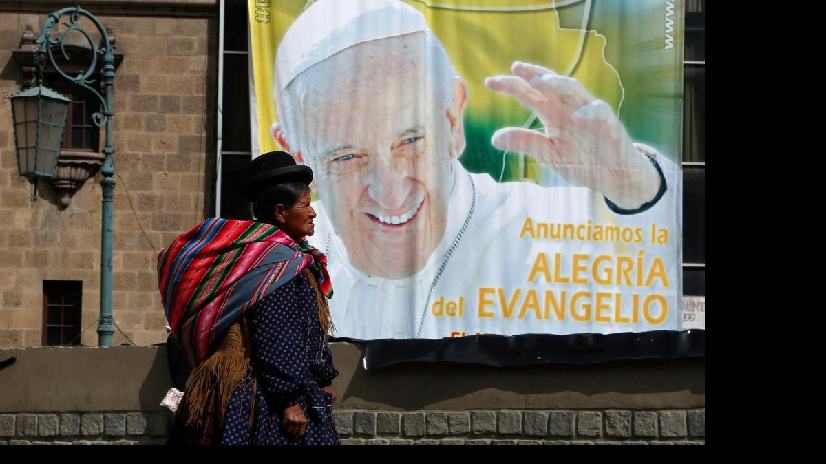
An Aymara indigenous woman walks past a billboard featuring Pope Francis with a message that reads in Spanish: "Announcing the joy of the Gospel" in La Paz, Bolivia, Friday, July 3, 2015. The pope's trip to South America that includes Bolivia is set for July 5-12, though he will only spend four hours in Bolivia's capital due to the altitude, church officials say.
