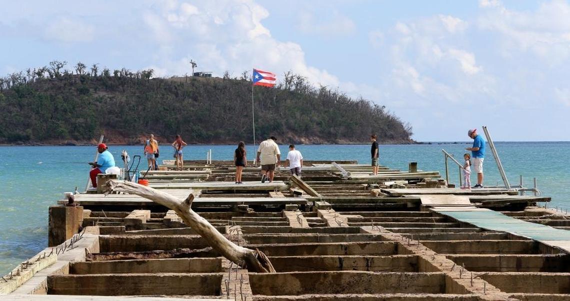 Visitors and fishermen stand on the Playa Punta Santiago pier in Humacao, Puerto Rico that was destroyed by Hurricane Maria, on Sunday, Dec. 03, 2017.
