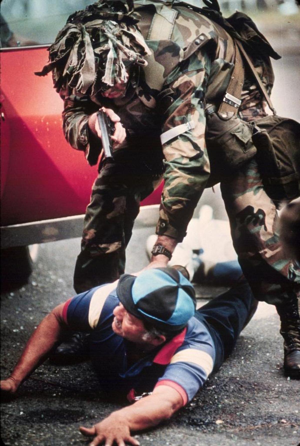 A member of the U.S. invasion force aims a .45 at the head of a Panamanian suspected of being a member of Manuel Noriega's defense forces who had shed his uniform and dressed in civilian clothing to escape detection.