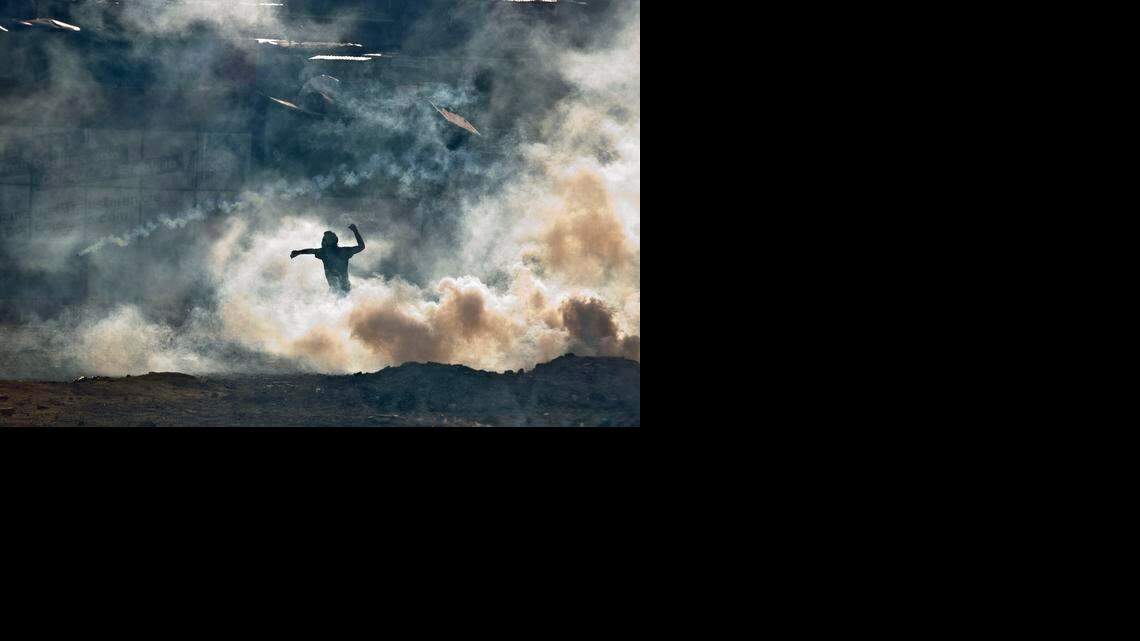 
A demonstrator standing in teargas fired by Bolivarian National Guards prepares to throw a rock during clashes near Plaza Altamira in Caracas, Venezuela, Sunday, March 16, 2014. Anti-government street protests by Venezuelans fed up with violent crime, shortages of basic items such as flour and cooking oil and high inflation have roiled Venezuela for more than a month. 
