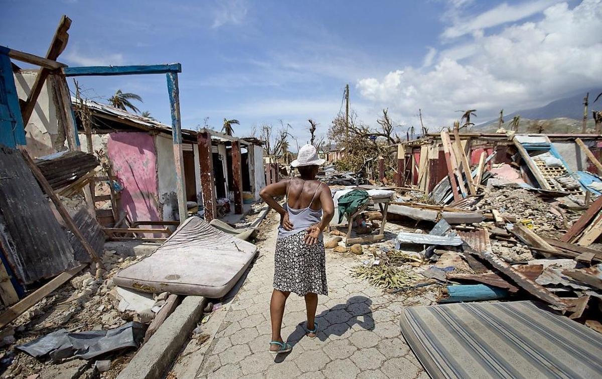 When Hurricane Matthew swept through Haiti last fall it left severe damage in the southern portion of the country. Here an elderly woman walks along a debris filled street in Roche a Bateau on Oct. 9, 2016.