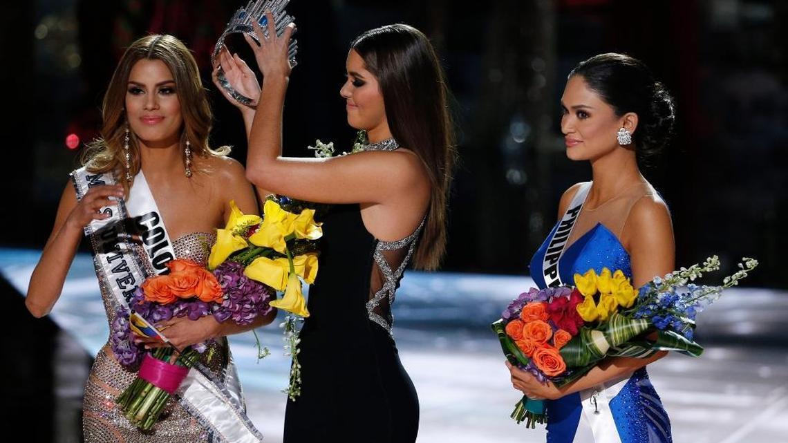 Former Miss Universe Paulina Vega, center, removes the crown from Miss Colombia Ariadna Gutierrez, left, before giving it to Miss Philippines Pia Alonzo Wurtzbach, right, at the Miss Universe pageant in Las Vegas. Gutierrez was incorrectly named the winner before Wurtzbach was given the Miss Universe crown. Colombians are now considering suing the pageant.