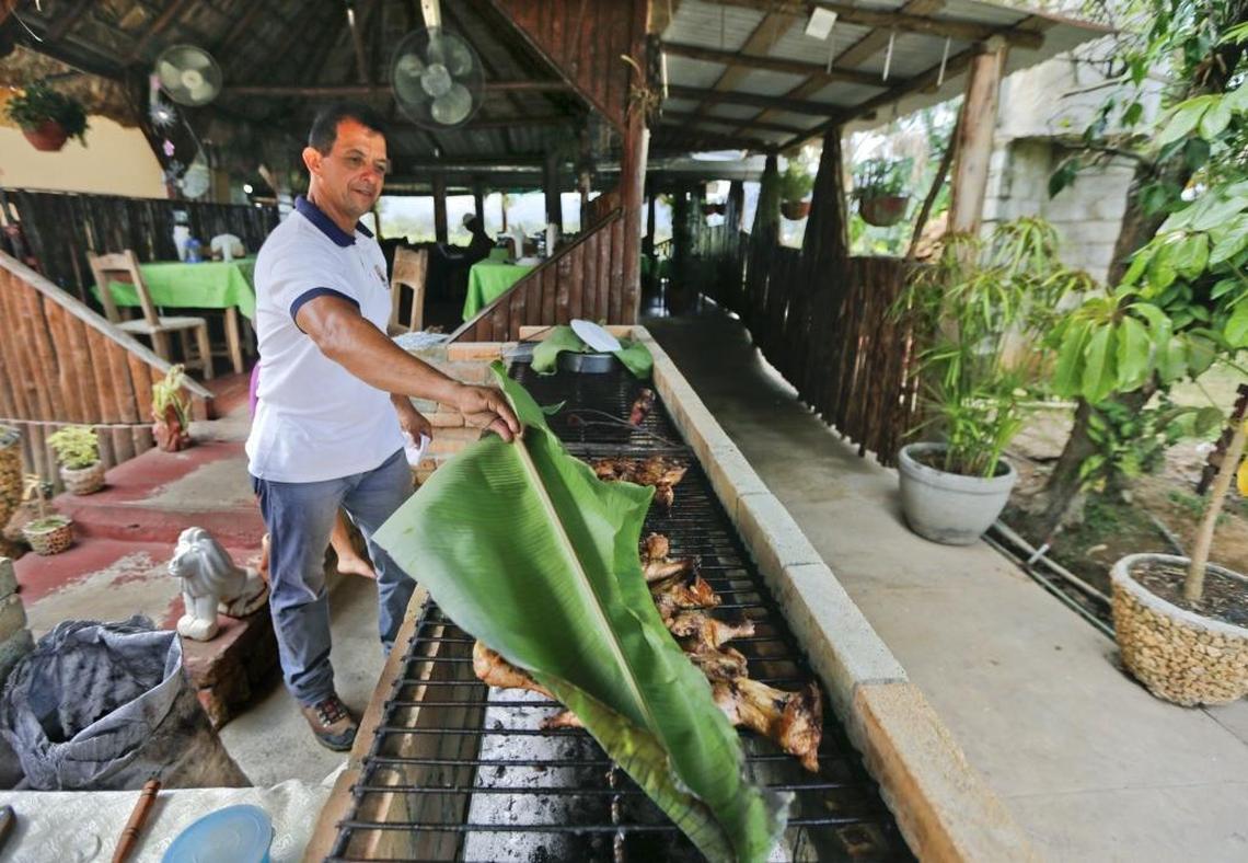 A banana leaf is used to cover chicken cooking on a BBQ grill at Yury & Nino El Campesino, a paladar and bar in Viñales, a town of self-employed entrepreneurs, known as cuentapropistas, in western Cuba on March 24, 2016.