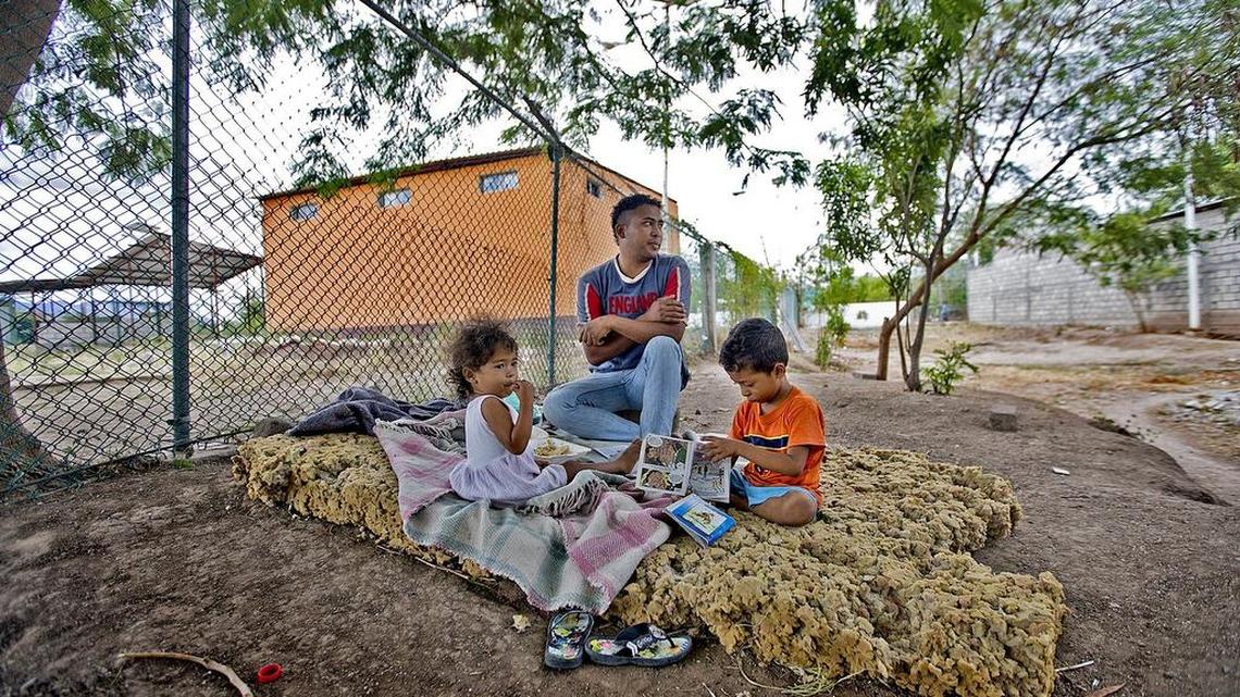 Marbin Oviedo, 25, sits with his children Justin, 4, and Katarin, 2 at the Migrant Shelter, Hermanos en el Camino, in Ixtepec, Mexico on October 17, 2015.