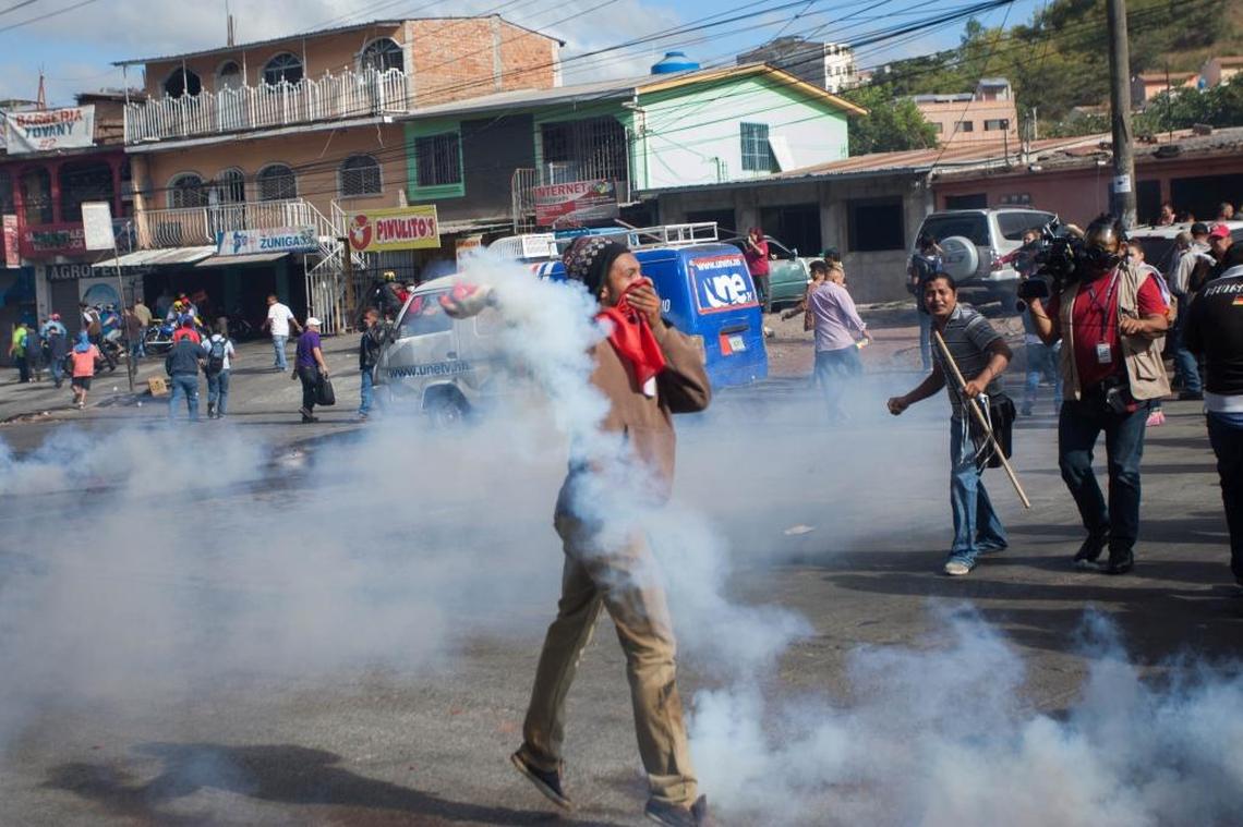A protester throws a tear gas canisters at police and military during a confrontation in Villanueva, Tegucigalpa, on Dec. 15, 2017.