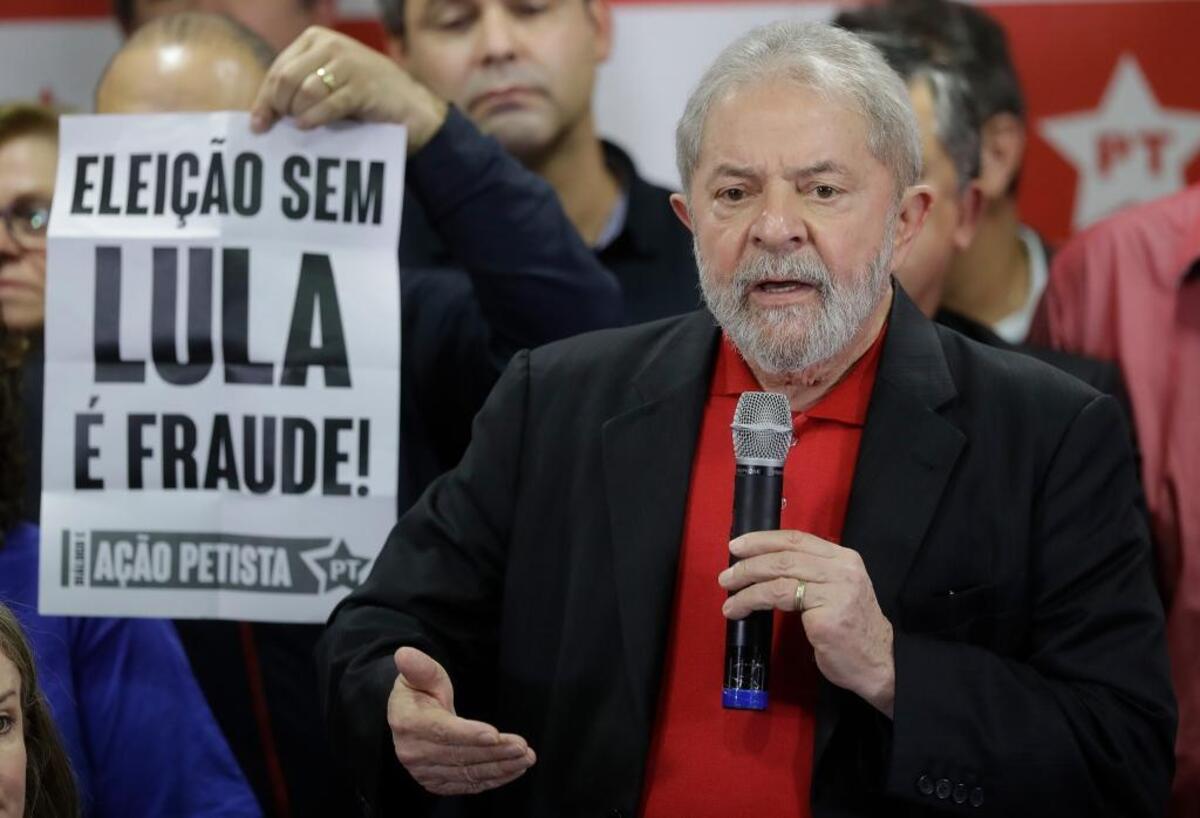 Former Brazilian President Luiz Inacio Lula da Silva delivers a brief speech to the media and supporters at the headquarters of the Worker's Party in Sao Paulo, Brazil. The sign reads in Portuguese: “Elections without Lula are fraud!"