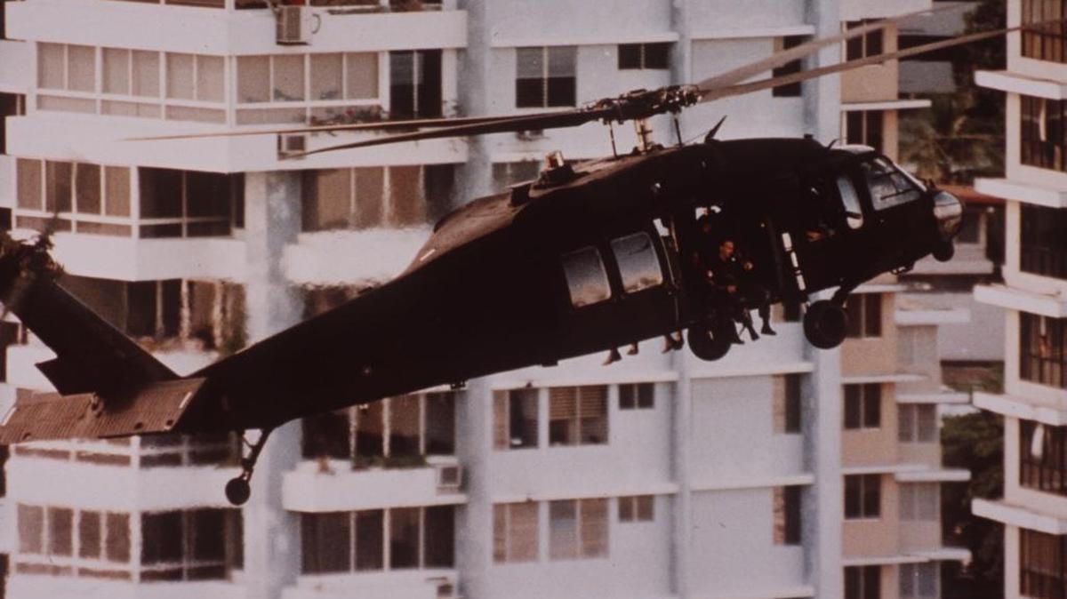 Days after the U.S. invasion, an army helicopter ferries reinforcements to the Vatican embassy in Panama City. Gen. Manuel Noriega has taken refuge in the embassy after U.S. troop advancement forced him into hiding.