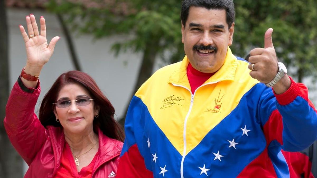 Venezuela's President Nicolas Maduro and first lady, Cilia Flores, left, gesture to supporter as they arrive at a poll station during ruling party primary elections in Caracas, Venezuela, Sunday, June 28, 2015. Two nephews of Flores’ have been arrested on charges of trying to smuggle cocaine into the U.S.