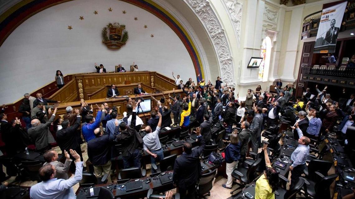 Opposition lawmaker raise their hands to approve activation of the procedure to remove magistrates from the Supreme Court during a session at the National Assembly in Caracas, Venezuela, Wednesday, April 05, 2017. The government over the weekend backed away from the Supreme Court's ruling after strong international and domestic criticism.