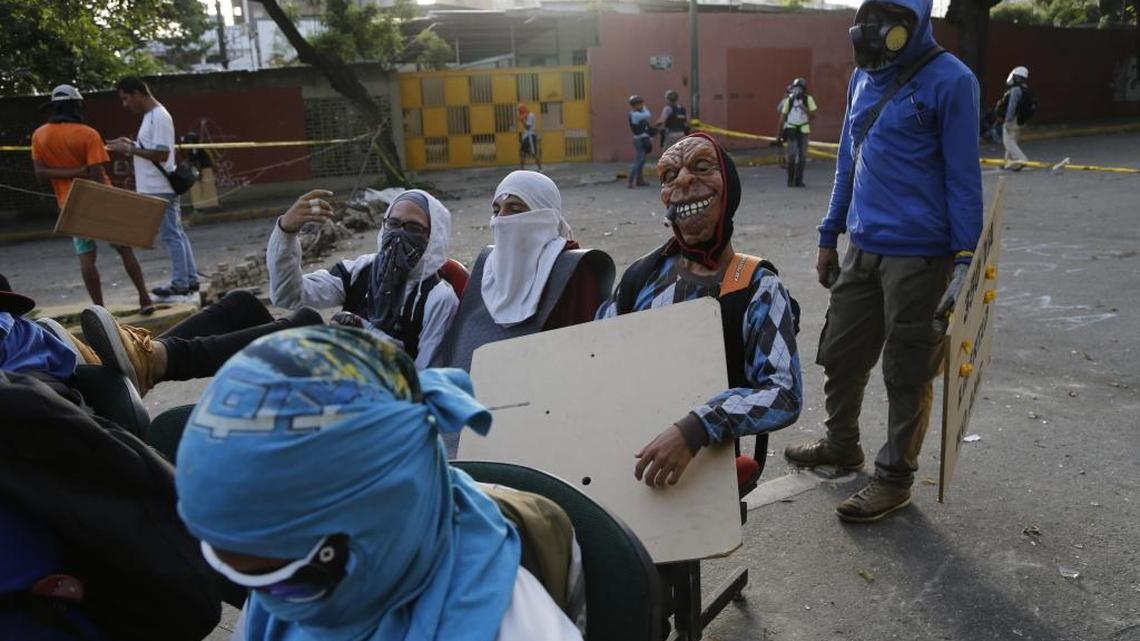 Anti-government demonstrators sit on furniture placed in the middle of the street during a call by the opposition to block roads for 10 hours in Caracas, Venezuela, Monday, July 10, 2017. Opposition protests demanding new elections and decrying triple-digit inflation, food shortages and worsening crime continue as President Nicolas Maduro pushes forward with his plan to draft a new constitution.