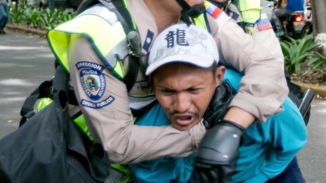 An anti-government protester is detained by Bolivarian National Police during a march toward the headquarters of the national electoral body, CNE, in Caracas, Venezuela, Wednesday, May 18, 2016. Police clashed with protesters trying to reach the CNE to demand a referendum to recall Venezuela's President Nicolas Maduro.