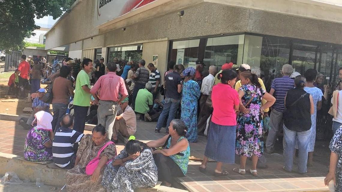 Older Venezuelans stand in line for hours outside banks every month to receive government pensions.