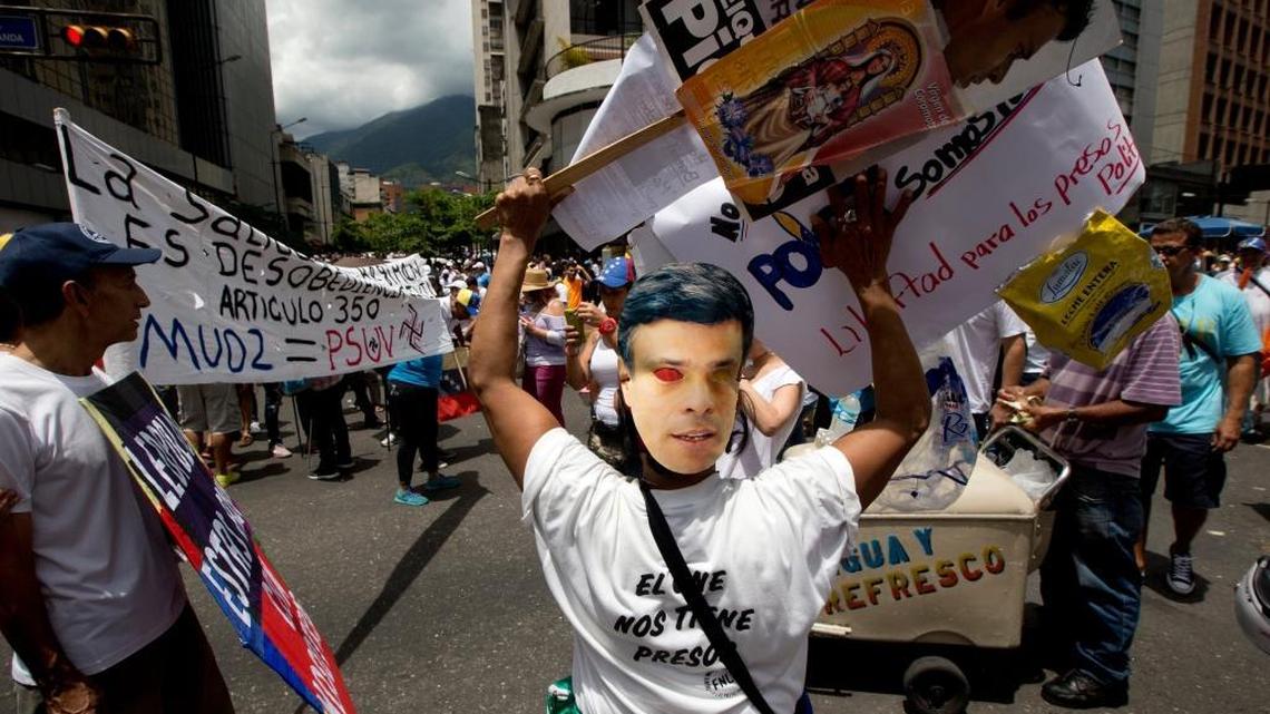 An opposition member wears a mask of jailed opposition leader Leopoldo Lopez during a rally in Caracas earlier this year, ahead of Dec. 6 elections.