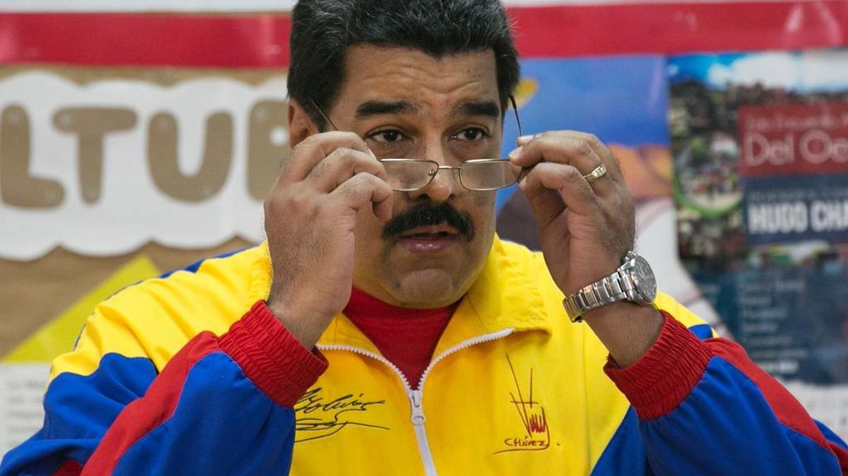 
FILE - In this June 28, 2015 file photo, Venezuela's President Nicolas Maduro puts on his eyeglasses at a polling station, before casting his ballot in his party's primary elections in Caracas, Venezuela. Maduro’s administration is cracking down on “mega gangs” in the country. 
