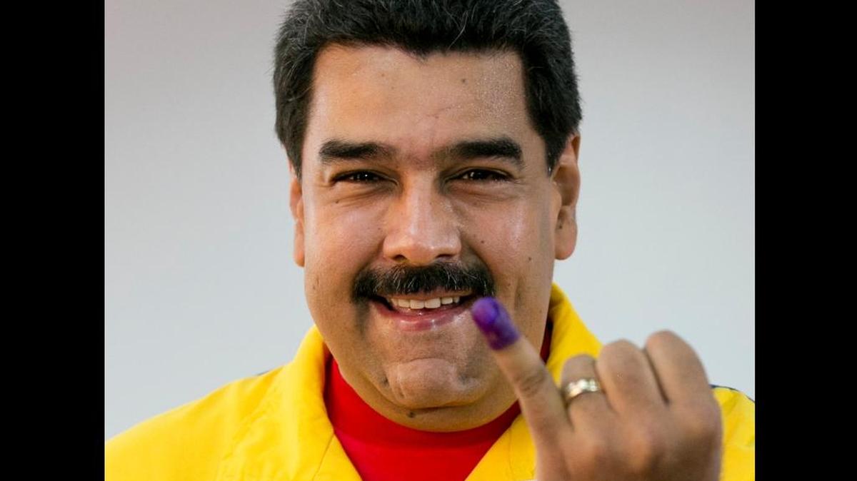 Venezuela’s President Nicolas Maduro shows his finger stained in ink after casting his ballot during the ruling party’s primaries in Caracas, Venezuela, June 28, 2015.
