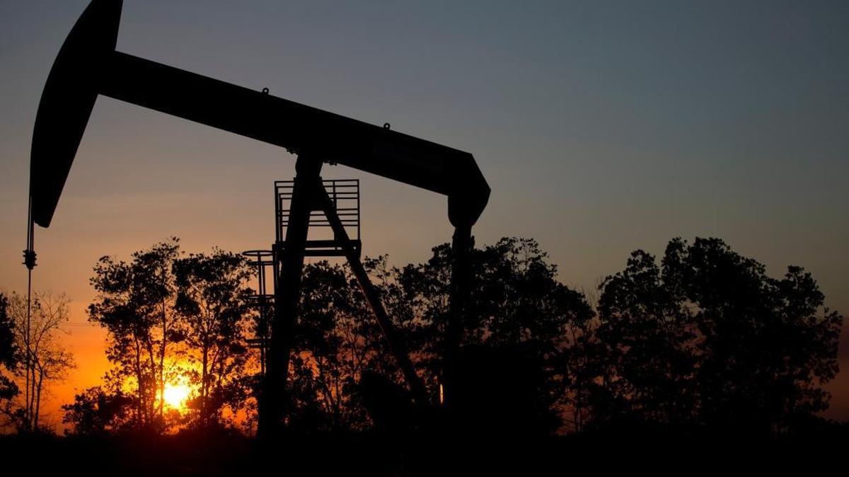 In this Feb. 19, 2015 photo, the sun sets behind an oil well in a field near El Tigre, a town within Venezuela's Hugo Chavez oil belt, formally known as the Orinoco Belt.