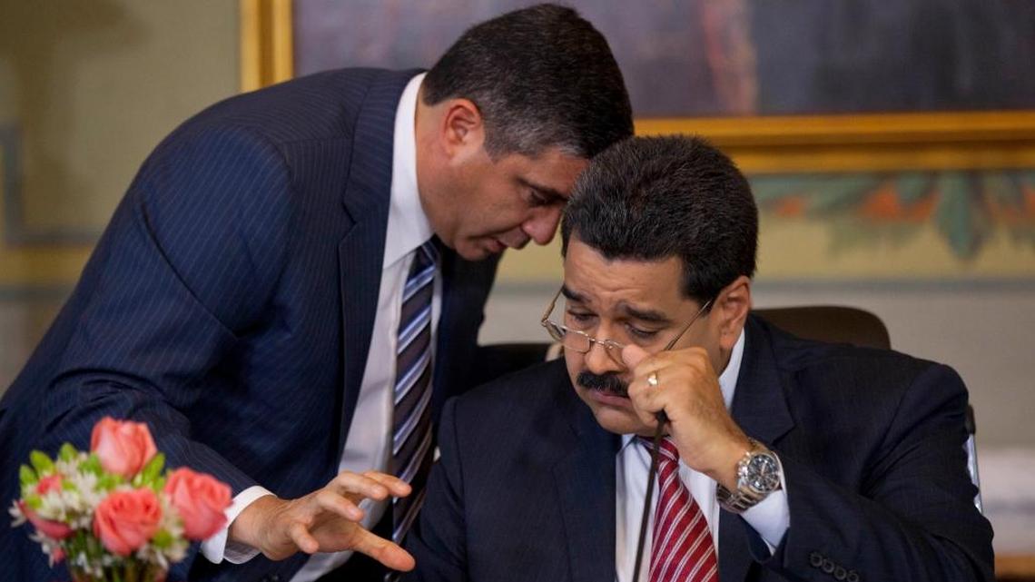 In this Oct. 15, 2014 file photo, Venezuela's Minister of Interior and Justice Miguel Rodriguez Torres, left, speaks with President Nicolas Maduro during a break at a press conference with the national and foreign media at Miraflores Presidential palace in Caracas, Venezuela. Torres, a former spy chief for Hugo Chavez who has been leading a movement of alienated leftists opposed to President Maduro, was hauled away Tuesday, March 13, 2018, by agents from the Sebin intelligence police, according to Torres' aides.