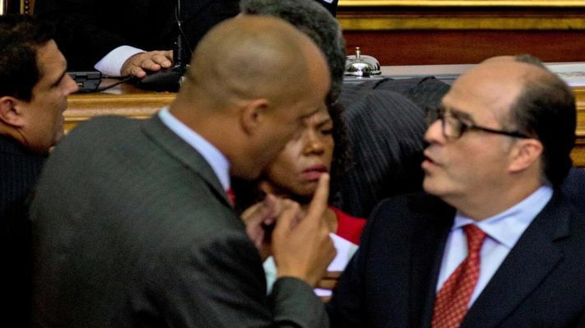 Incoming parliamentary president, Henry Ramos Allup, sits in the speaker’s chair, as congressmen Julio Borges, of the opposition, bottom right, and Héctor Rodríguez, of the ruling party, argue inside the National Assembly, in Caracas, Venezuela, Tuesday, Jan. 5, 2016. With tensions running high inside the legislature and dueling demonstrations by government supporters and opponents outside, lawmakers took their oath Tuesday. A group of pro-government lawmakers walked out in protest after storming the legislature’s dais as the new congressional leadership laid out its legislative agenda.