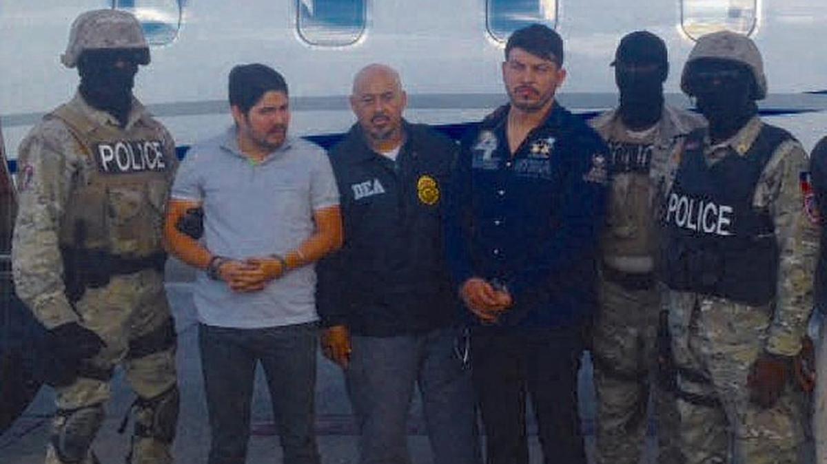 Efrain A. Campo, second from left and Franki F. Flores, fourth from left, handcuffed after his arrest in Haiti.