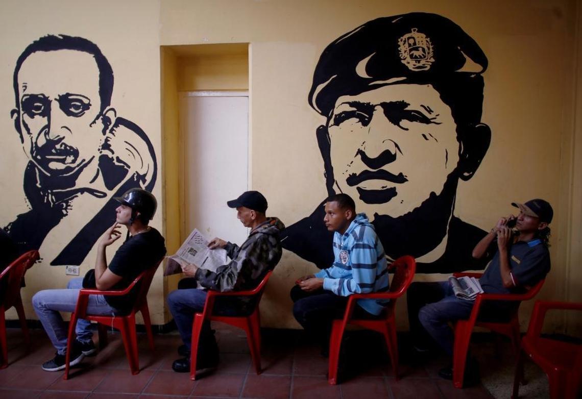 Voters wait to cast their ballots next murals of Venezuelan independence hero Ezequiel Zamora, left, and the late Venezuelan President Hugo Chávez at a polling station in Caracas on Sunday.
