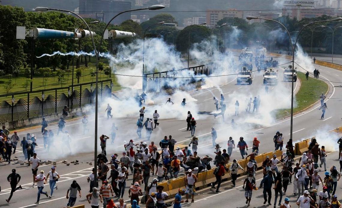 Bolivarian National Guard launch tear gas at anti-government protesters in Caracas, Venezuela, Wednesday, April 19, 2017. Tens of thousands of opponents of President Nicolas Maduro flooded the streets of Caracas in what's been dubbed the "mother of all marches" against the embattled president.