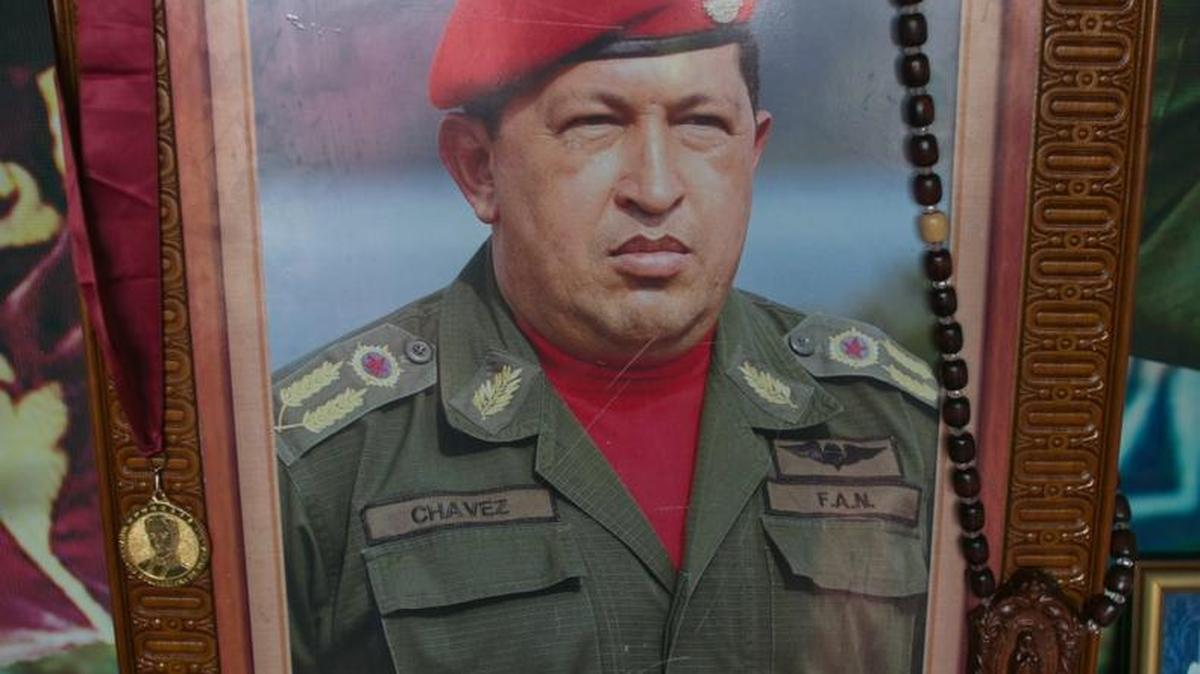 A photo of Venezuela's late president Hugo Chavez is seen inside a small chapel with two cups of coffee as an offering at the 4F military museum to commemorate what would have been the leader's 62th birthday in Caracas, Venezuela. With Chavez's hand picked successor Nicolas Maduro as president, the socialist government of Venezuela is digging in its heels to stop a presidential recall vote.