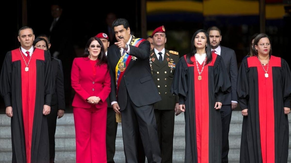 In this Jan. 15, 2017 file photo, Venezuela's President Nicolas Maduro speaks with first lady Cilia Flores as they arrive at the Supreme Court before he delivered his state of the union address in Caracas, Venezuela. Venezuela's Supreme Court ruled Wednesday night that it can take over responsibilities assigned to Congress. Justices pictured from left to right; Supreme Court Vice President Maikel Moreno; Supreme Court President Gladys Gutierrez; and Supreme Court Justice Indira Alfonso.