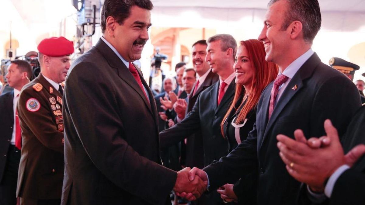 Venezuela's President Nicolas Maduro (C) shakes hands with Venezuela's new Vice-President Tarek El Aissami (R) during a meeting with ministers at a military fort in Caracas, Venezuela, on January 4, 2017. Miraflores Palace/Handout