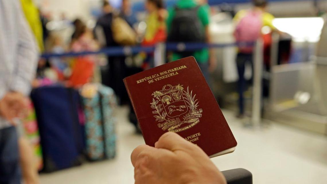 In this photo taken Wednesday, June 25, 2014, a passenger holds his Venezuelan passport as he prepares to travel to Venezuela at Miami International Airport in Miami.