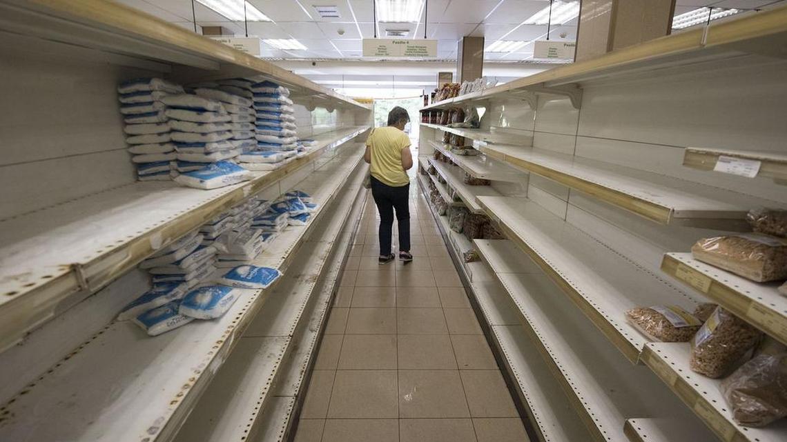 A customer shops amid empty shelves at a supermarket in Caracas, Venezuela, on July 25, 2017.