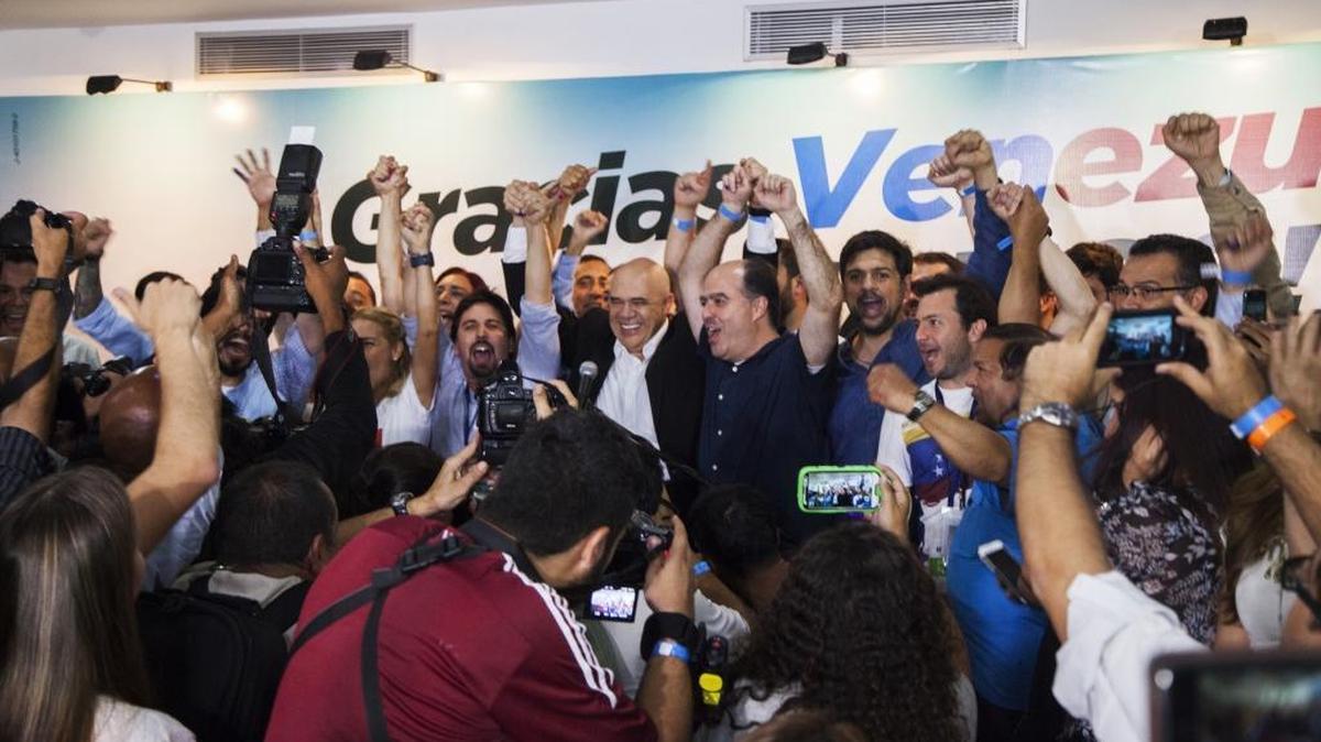 Jesus “Chuo” Torrealba, opposition leader, center, and members of Venezuela’s opposition alliance react during the announcement that the alliance won a majority in the Venezuelan congress in elections on Sunday.