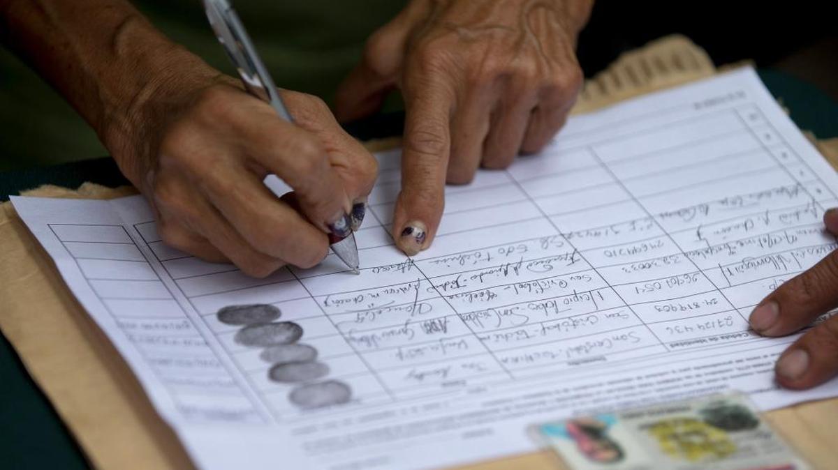 A person signs a petition to initiate a recall referendum against Venezuelan President Nicolas Maduro in San Cristobal, Venezuela, Wednesday, April 27, 2016.