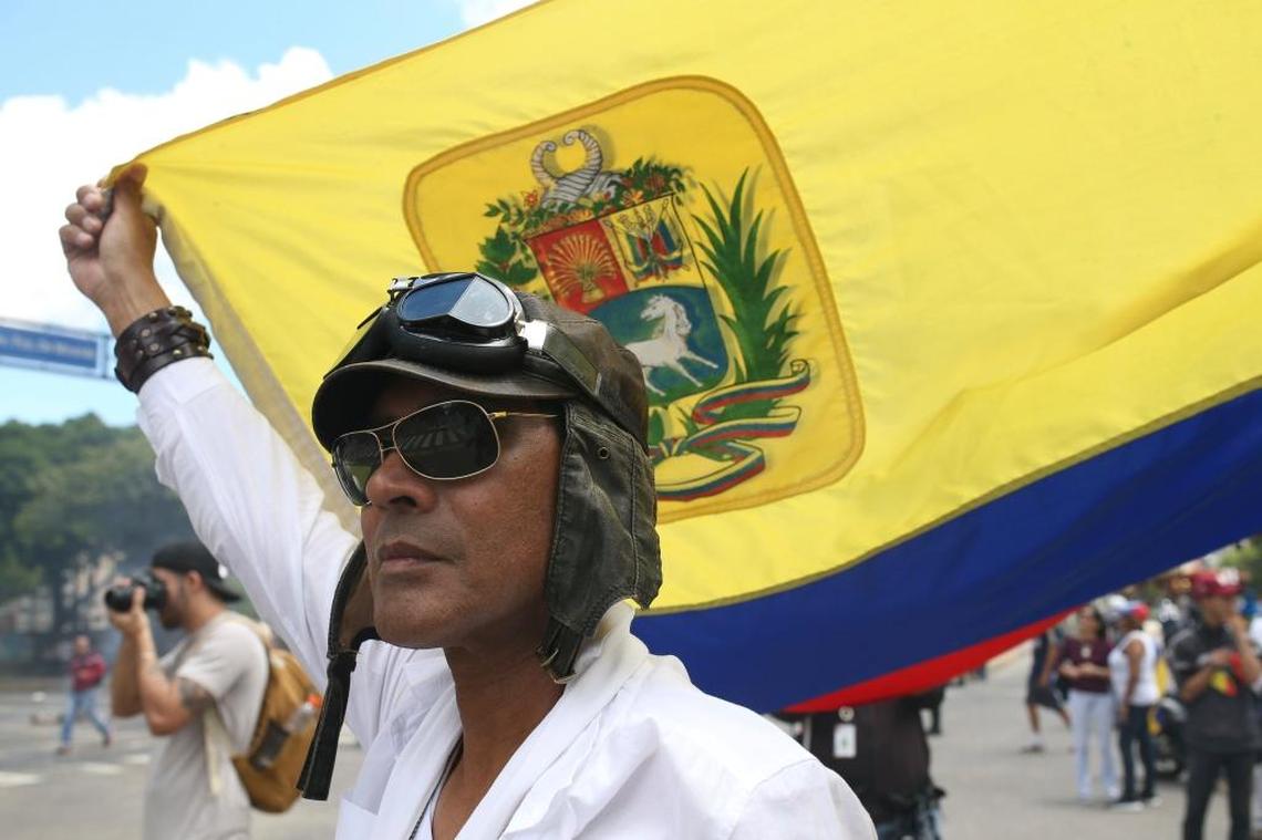 An anti-government demonstrator waves a Venezuelan flag Friday in Caracas.