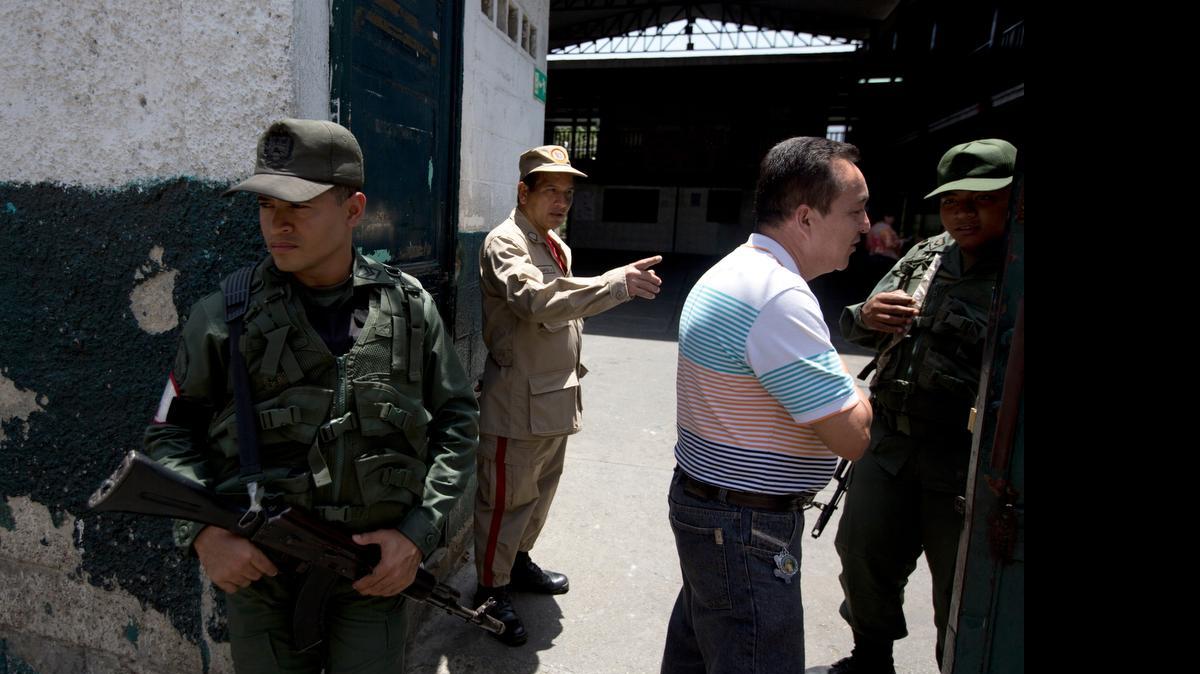 
An opposition voter is directed towards his voting area by Bolivarian National Guards officers upon his arrival to a poll station in Caracas, Venezuela, Sunday, May 17, 2015. Venezuelans are voting to select the opposition leaders who will run against the ruling socialist party’s candidates in upcoming legislative elections thought to be government critics’ first chance at an electoral victory in years.
