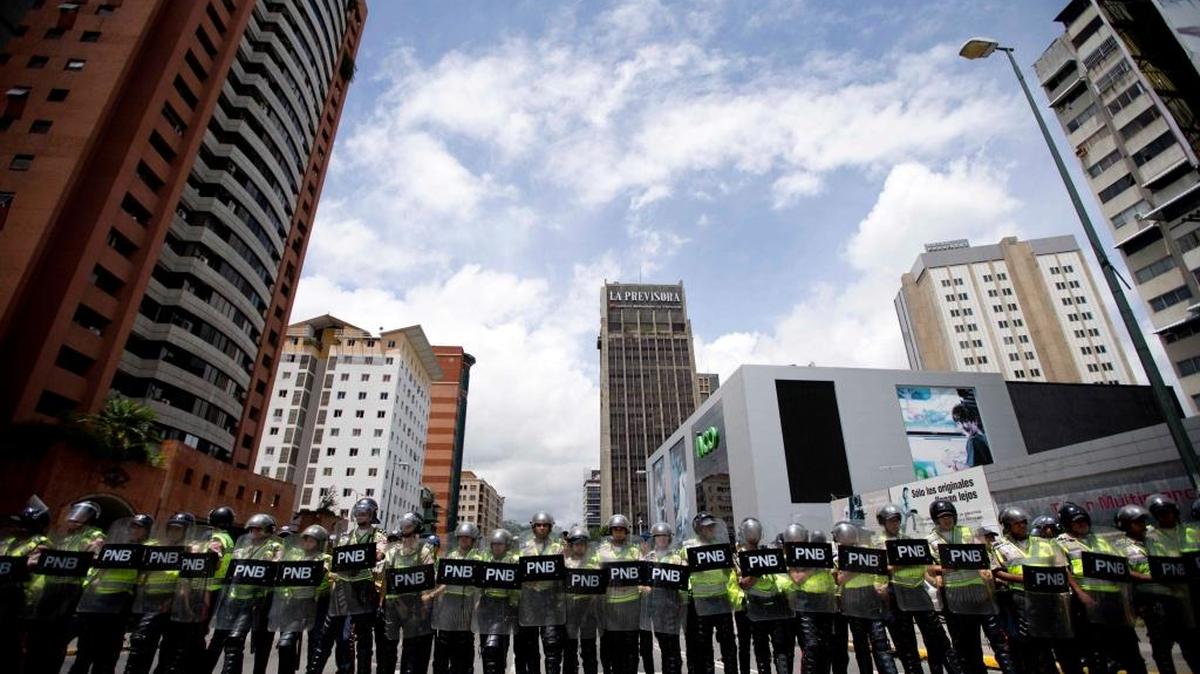 A cordon of Bolivarian National Police block an avenue to prevent opposition marchers from reaching the National Electoral Council building in Caracas, Venezuela, on Wednesday, July 27, 2016. Venezuela's opposition marched Wednesday to demand electoral officials go forth with the recall referendum process against Nicolás Maduro.