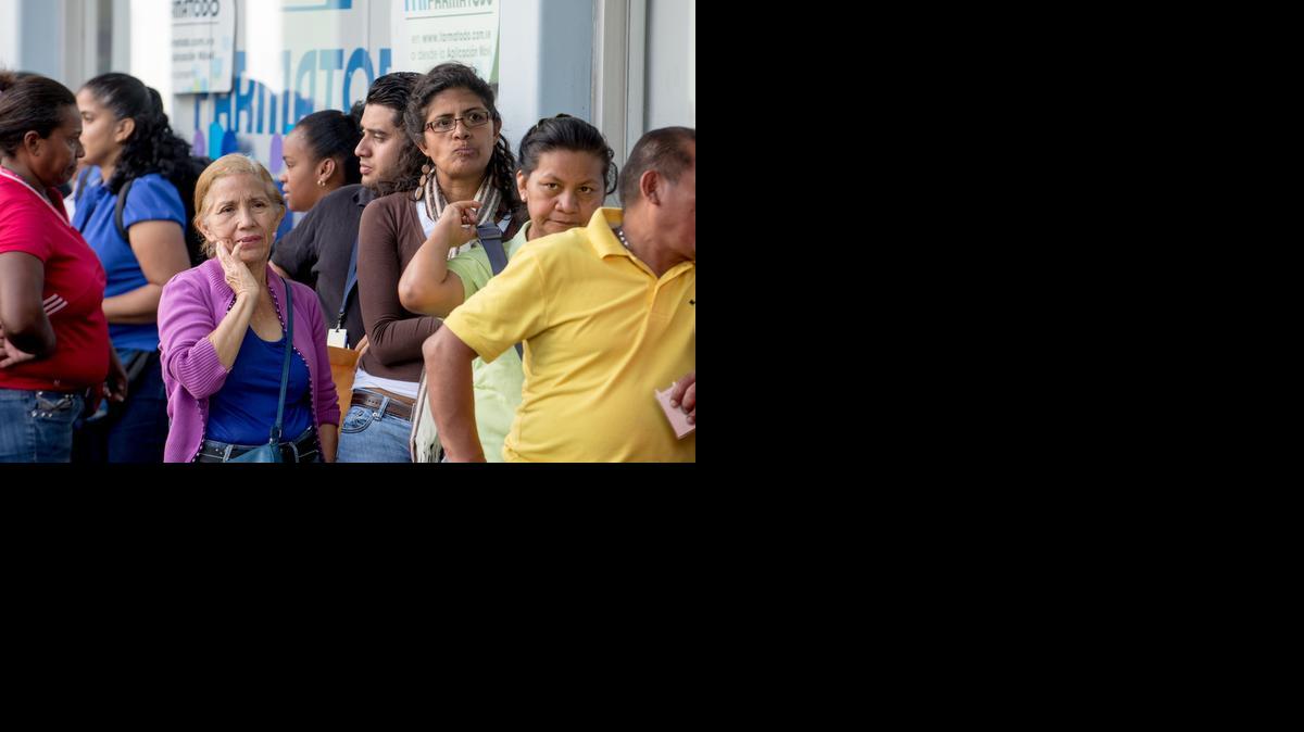 
People queue Tuesday outside a pharmacy in Caracas. Venezuela suffers from shortages of nearly a third of all basic goods, inflation that ballooned to 64 percent in 2014 and a recession triggered in part by a scarcity of hard currency that limits imports of essential goods. 
