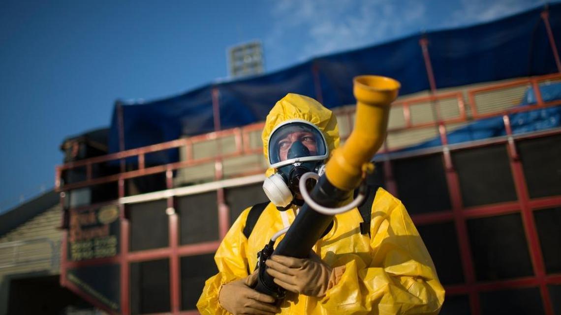 A health worker stands in the Sambadrome as he sprays insecticide to combat the Aedes aegypti mosquitoes that transmit the Zika virus, in Rio de Janeiro, Brazil, on Tuesday, Jan. 26, 2016.