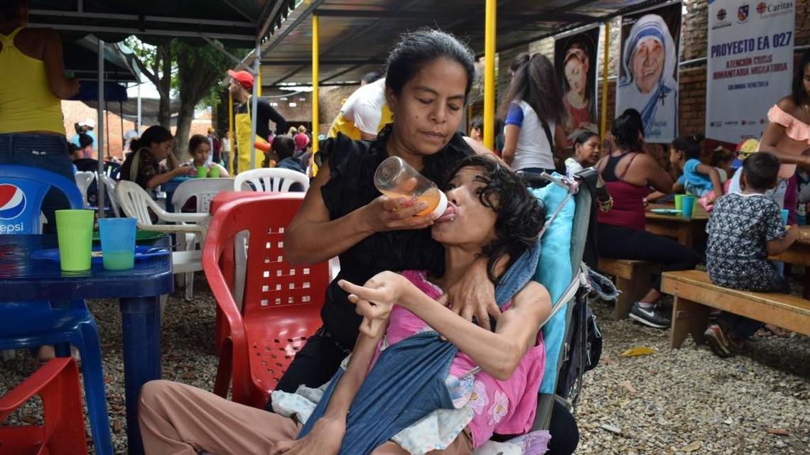Yasmira Gordillo, 46, feeds her daughter Maria, 19, in Cúcuta, Colombia. The woman traveled 14 hours by bus from Valencia, Venezuela, with her daughter in order to find the necessary anti-seizure medication for Maria, who has cerebral palsy.