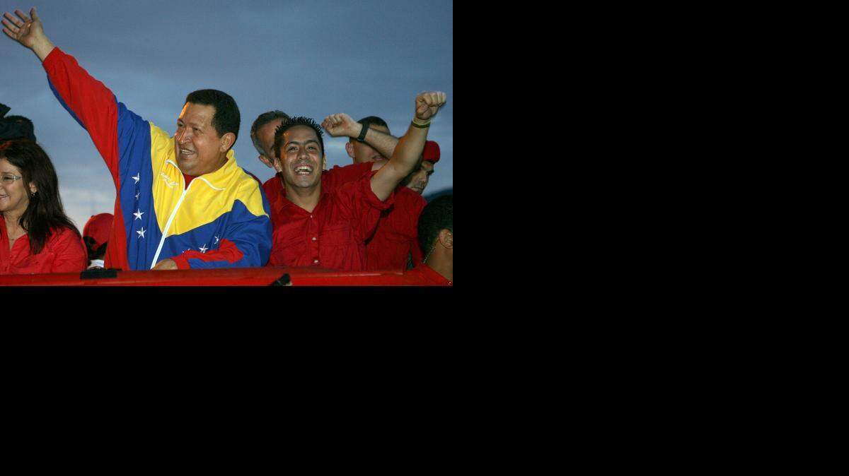 
FILE-Venezuelan President Hugo Chavez (L) and the candidate of their party for the parliamentary elections Robert Serra (R) greet supporters during a rally in Caracas on August 30, 2010. Robert Serra, was found shot dead at his home in Caracas on October 2, 2014. 
