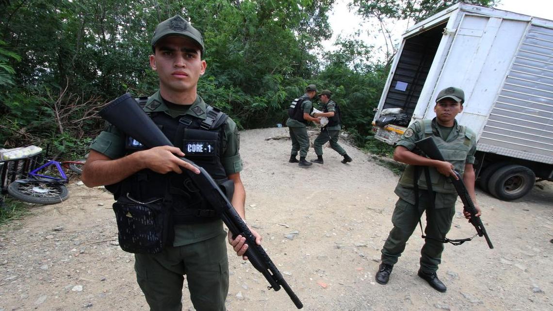 
In this Monday, March 9, 2015 photo, Venezuelan Bolivarian National Guard officers handle seized merchandise that was being smuggled as others stand guard during a mission to stem the flow of contraband in San Antonio, Venezuela. President Nicolas Maduro almost daily blames the smuggling as a tool used by his enemies and business elites fighting an economic war to oust his socialist government from power. 
