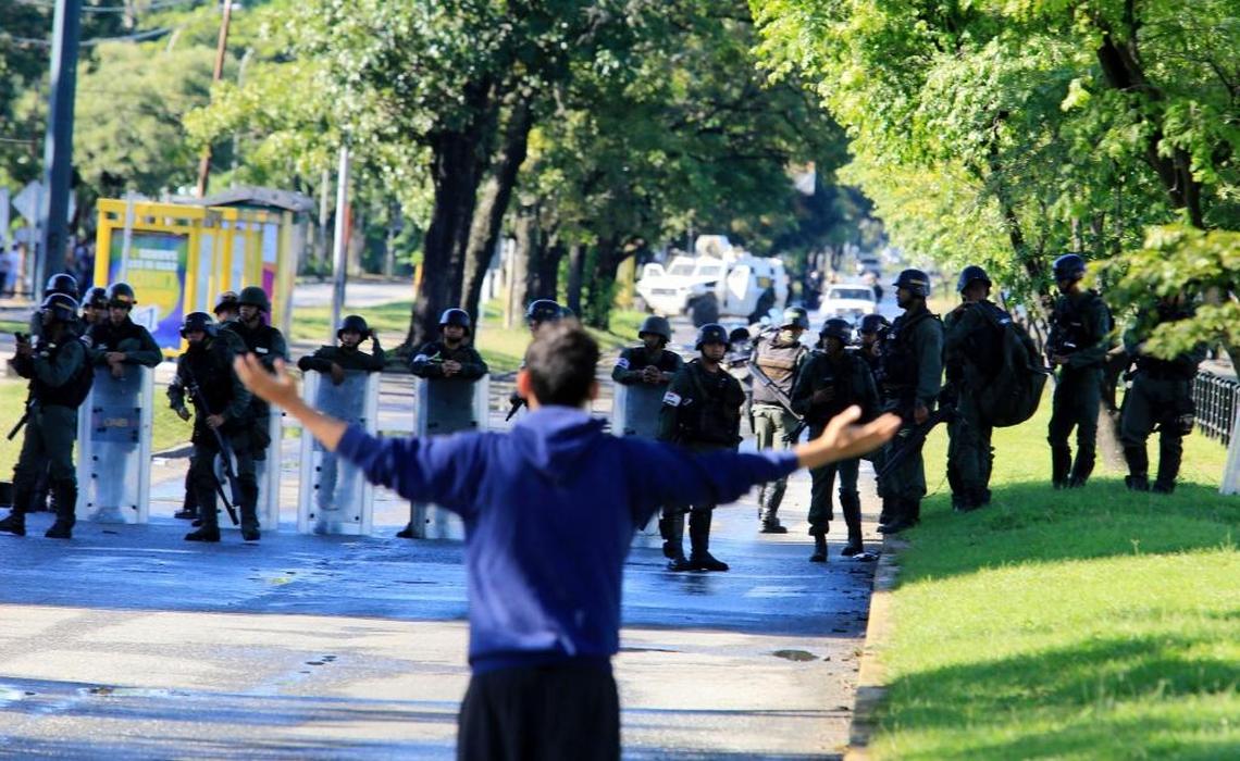A man argues with a Bolivarian National Guards officers outside the Paramacay military base in Valencia.