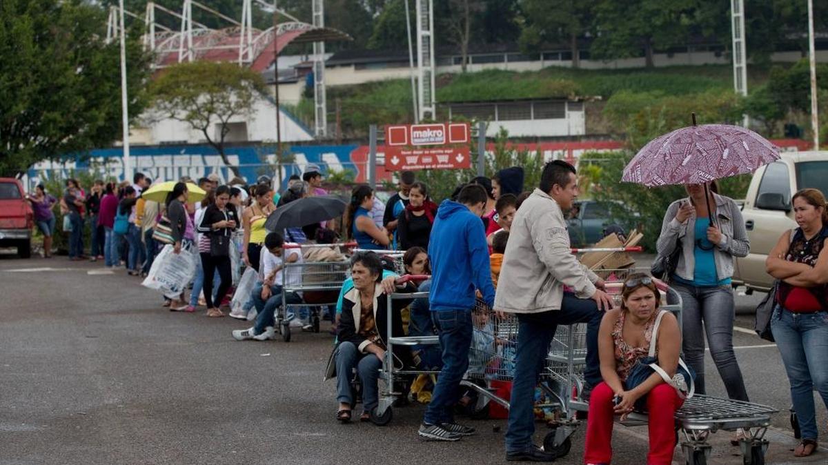 Patrons line up on a supermarket parking lot in San Cristobal, Venezuela, Thursday, Jan. 22, 2015. The combination of shortages and spiraling inflation have shaken support for President Nicolas Maduro even among the poor who rely on the social programs launched by his mentor, the late President Hugo Chavez.