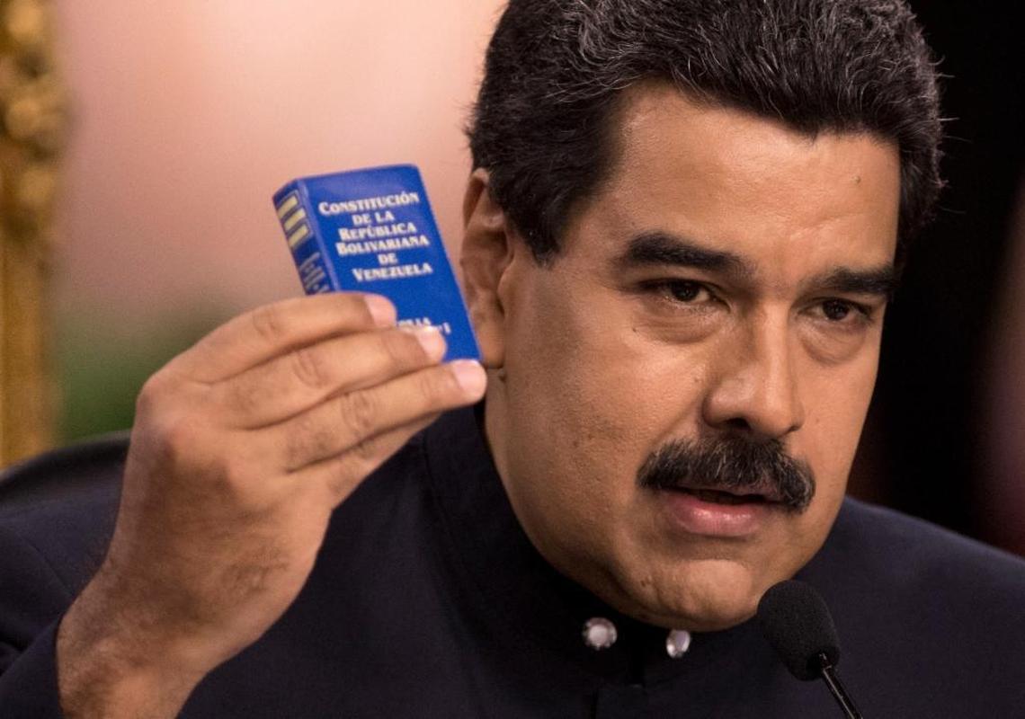 Venezuela's President Nicolas Maduro holds a copy of the constitution, as he speaks during a news conference in Caracas, Venezuela, Tuesday, Aug. 22, 2017. Immigration authorities in Colombia announced that Venezuela's ousted chief prosecutor Luisa Ortega Diaz is on her way to Brazil. Ortega said Maduro removed her in order to stop a probe linking him and his inner circle to nearly $100 million in bribes from Brazilian construction company Odebrecht.