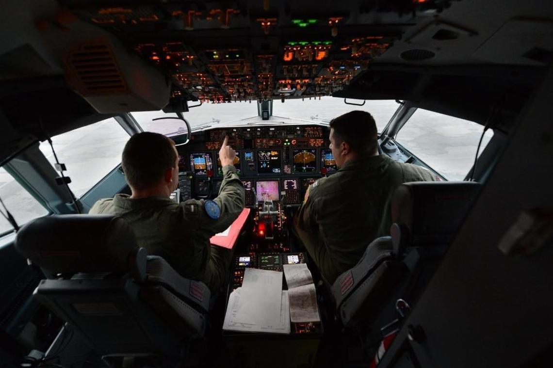U.S. Navy aviators perform preflight checks in the flight station of the P-8A Poseidon prior to a mission on April 1, 2014, from Perth, Australia, to assist in search and rescue operations for Malaysia Airlines flight MH370.