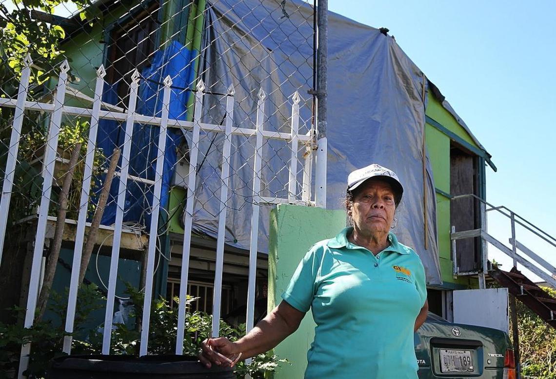 Gladys Peña, member of Proyecto Enlace, in front of her damaged home near Caño Martín Peña.