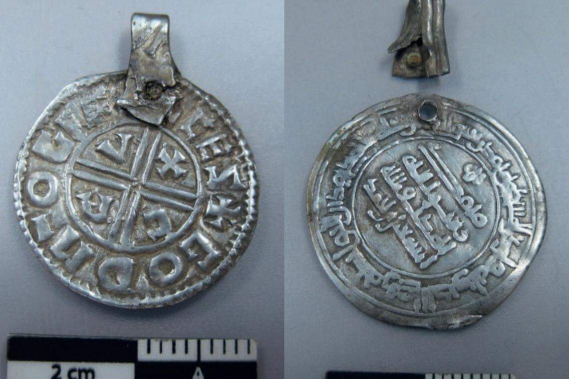 Two of the silver coin pendants found in Täby as seen after being cleaned.