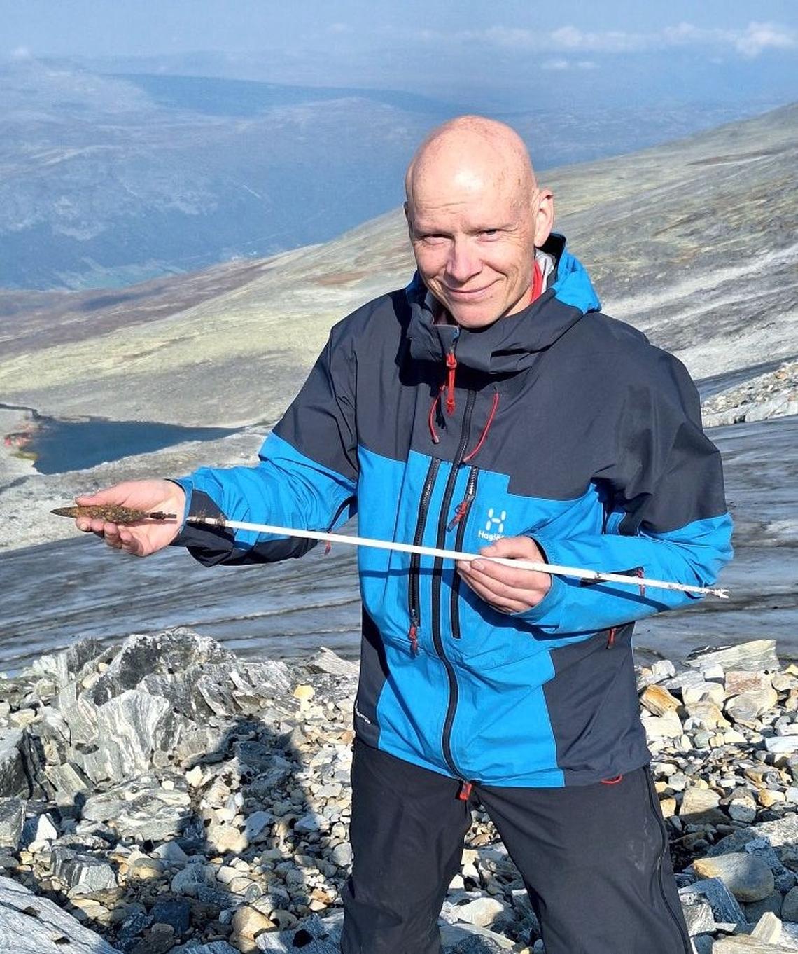 An archaeologist holds an early iron age arrow found at Lendbreen.