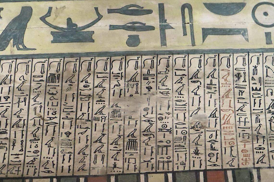 A close-up photo shows some of the decoration on the ancient coffins.
